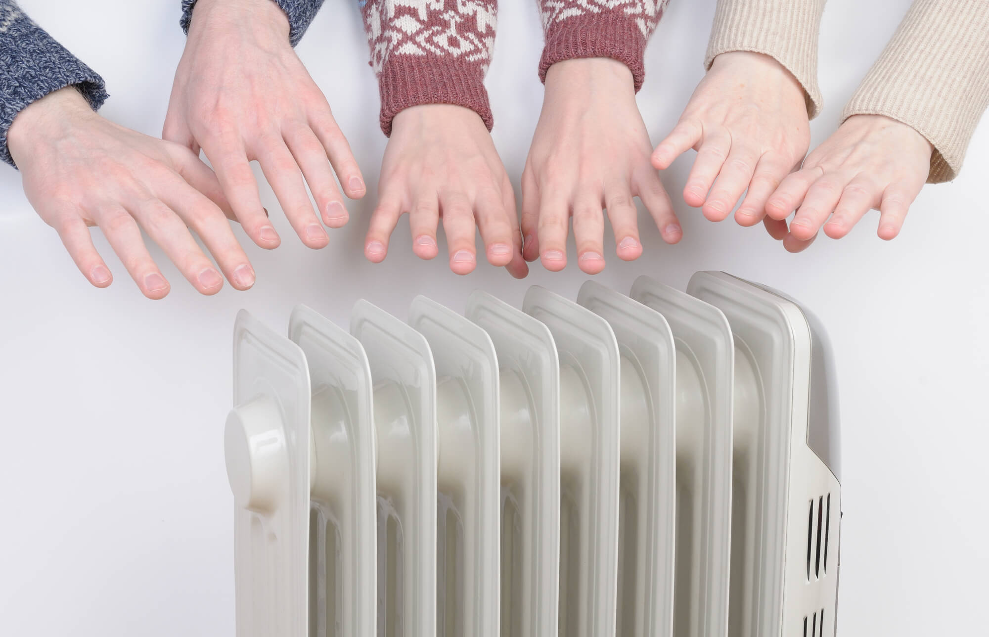 Hands warming near an electric radiator